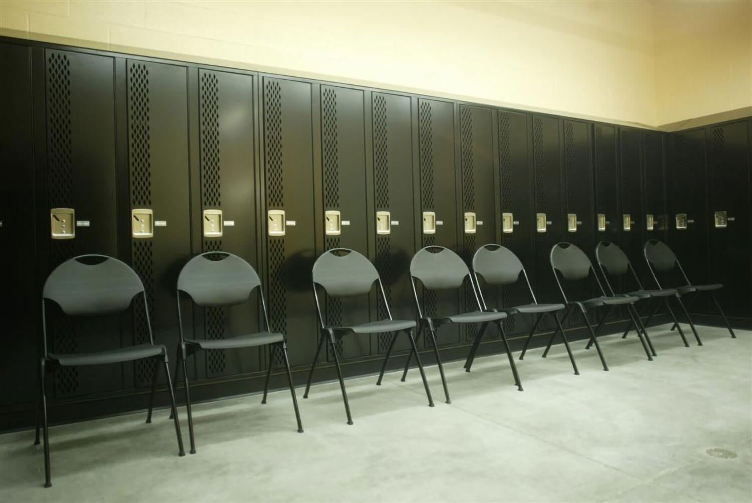 Locker room, folding chairs line up in front of lockers